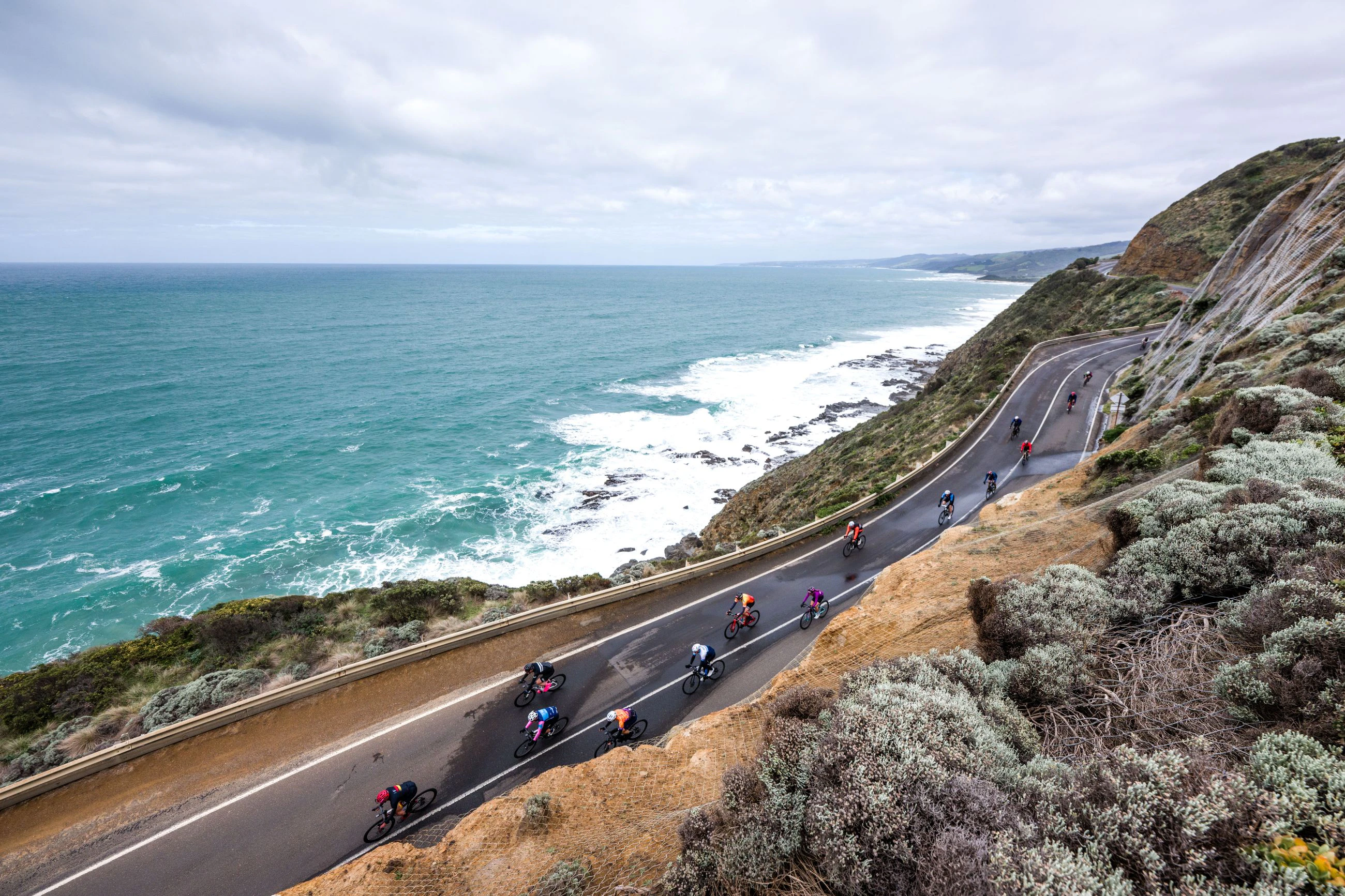 Road cyclists ride along the Great Ocean Road next to the ocean during the 2024 Amy's Gran Fondo. Photo by Alex Polizzi, RaceAtlas.