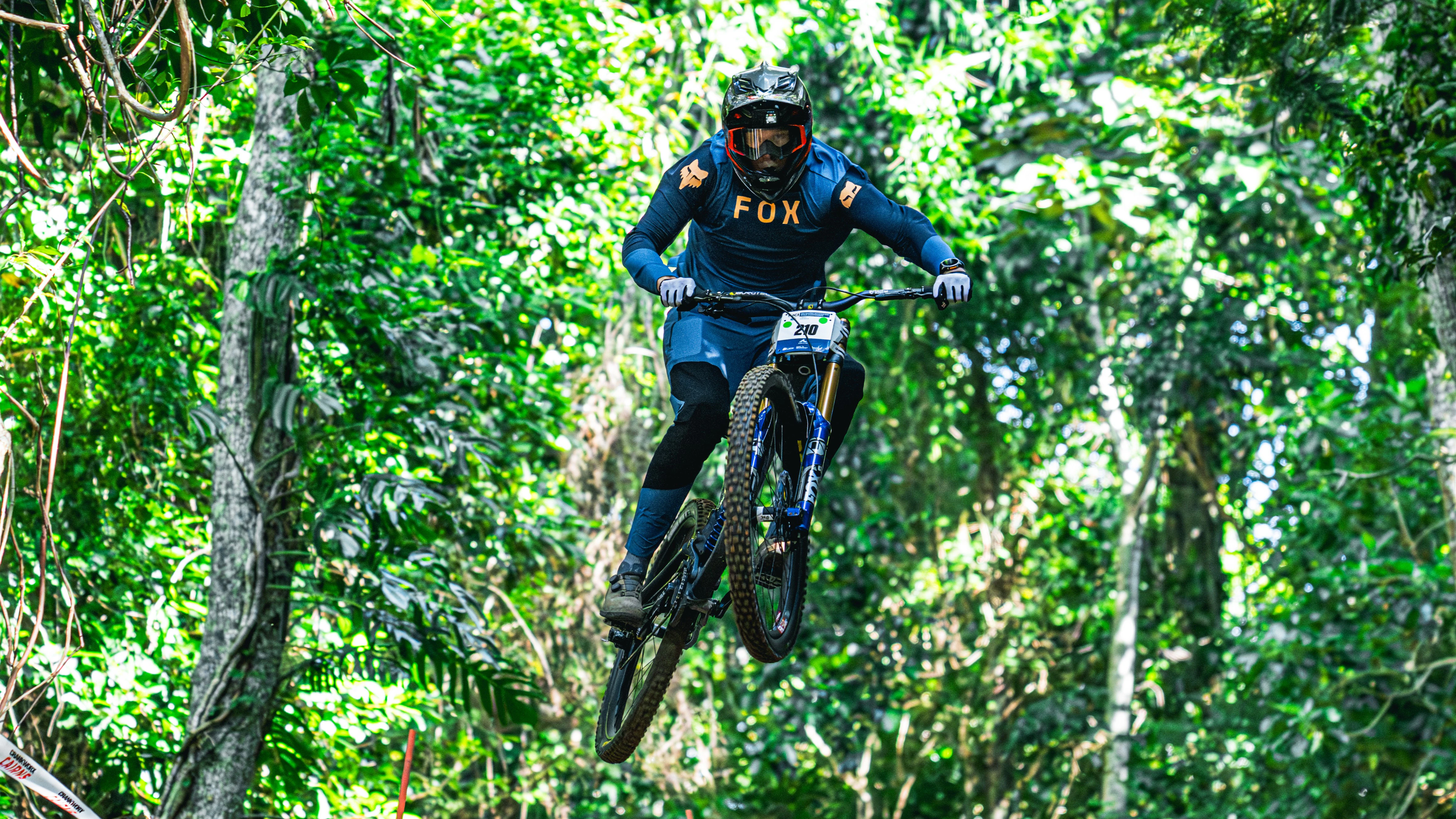 A Downhill mountain bike rider, number 210, at the UCI Masters MTB World Championships in Cairns, 2025