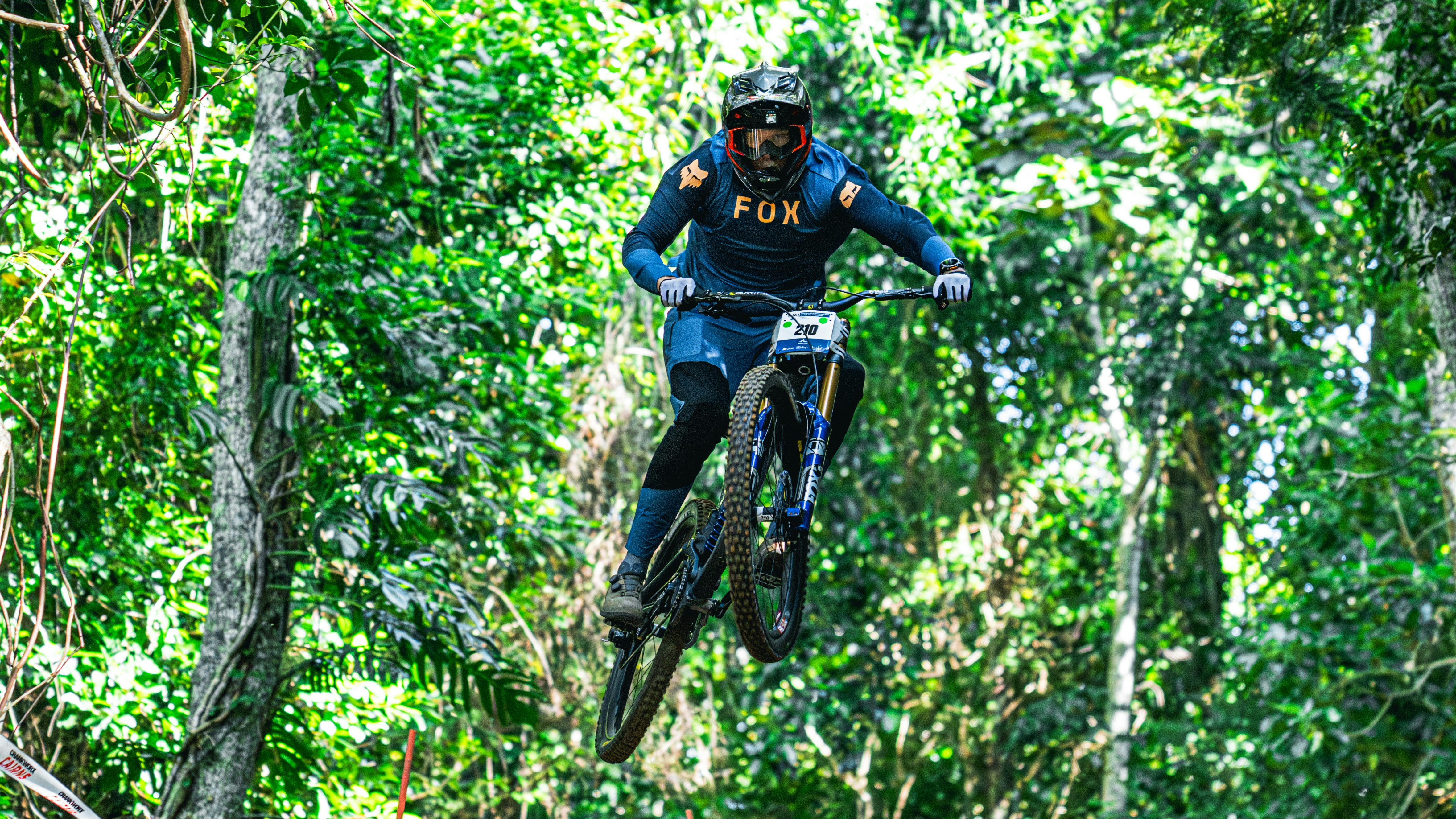 A Downhill mountain bike rider, number 210, at the UCI Masters MTB World Championships in Cairns, 2025