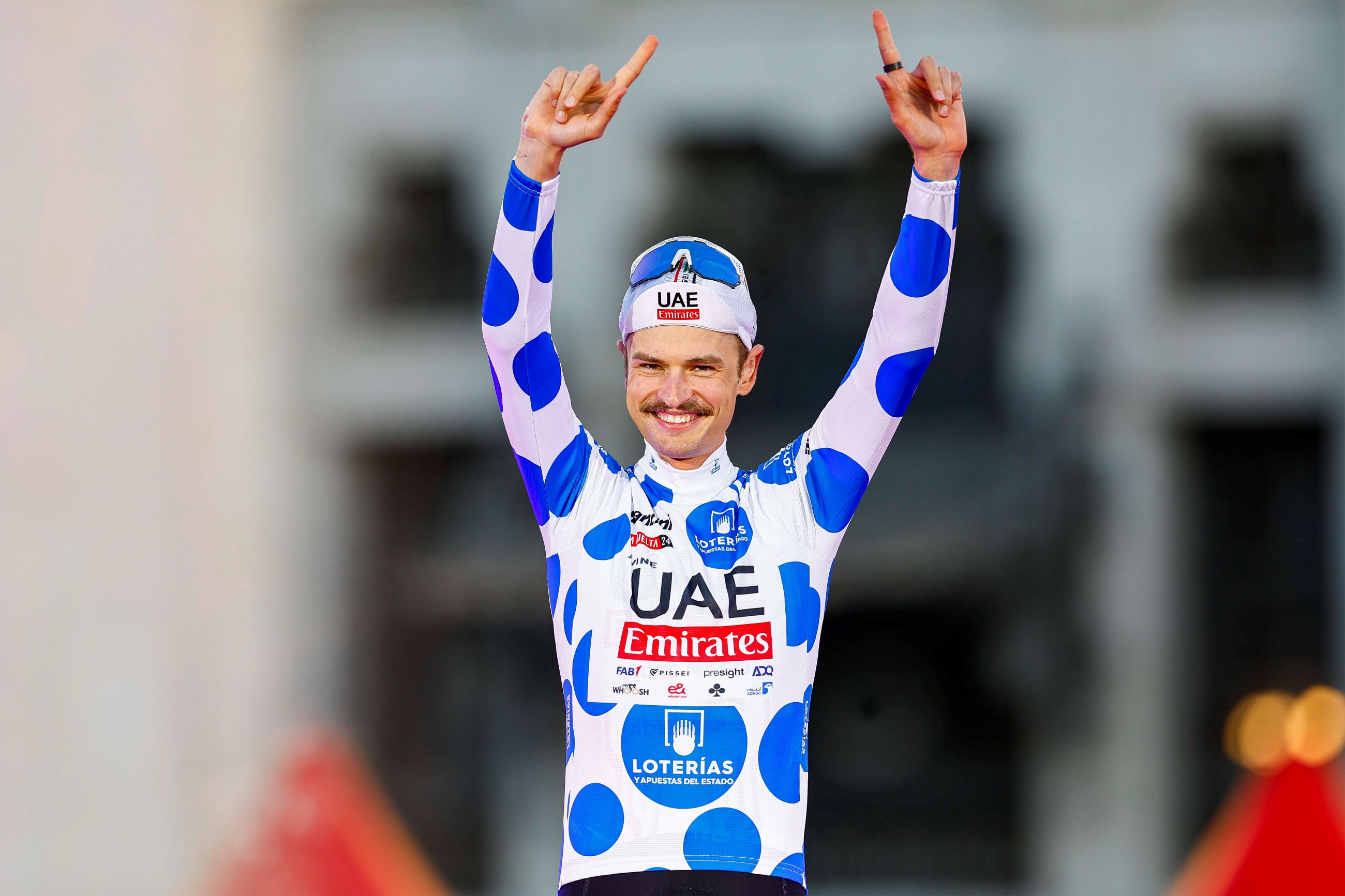 Australian road cyclist Jay Vine in the polka-dot jersey of the king of the mountains (KOM) classification winner on the final podium of the 2024 Vuelta a Espana in Madrid. Photo by Unipublic / Sprint Cycling Agency