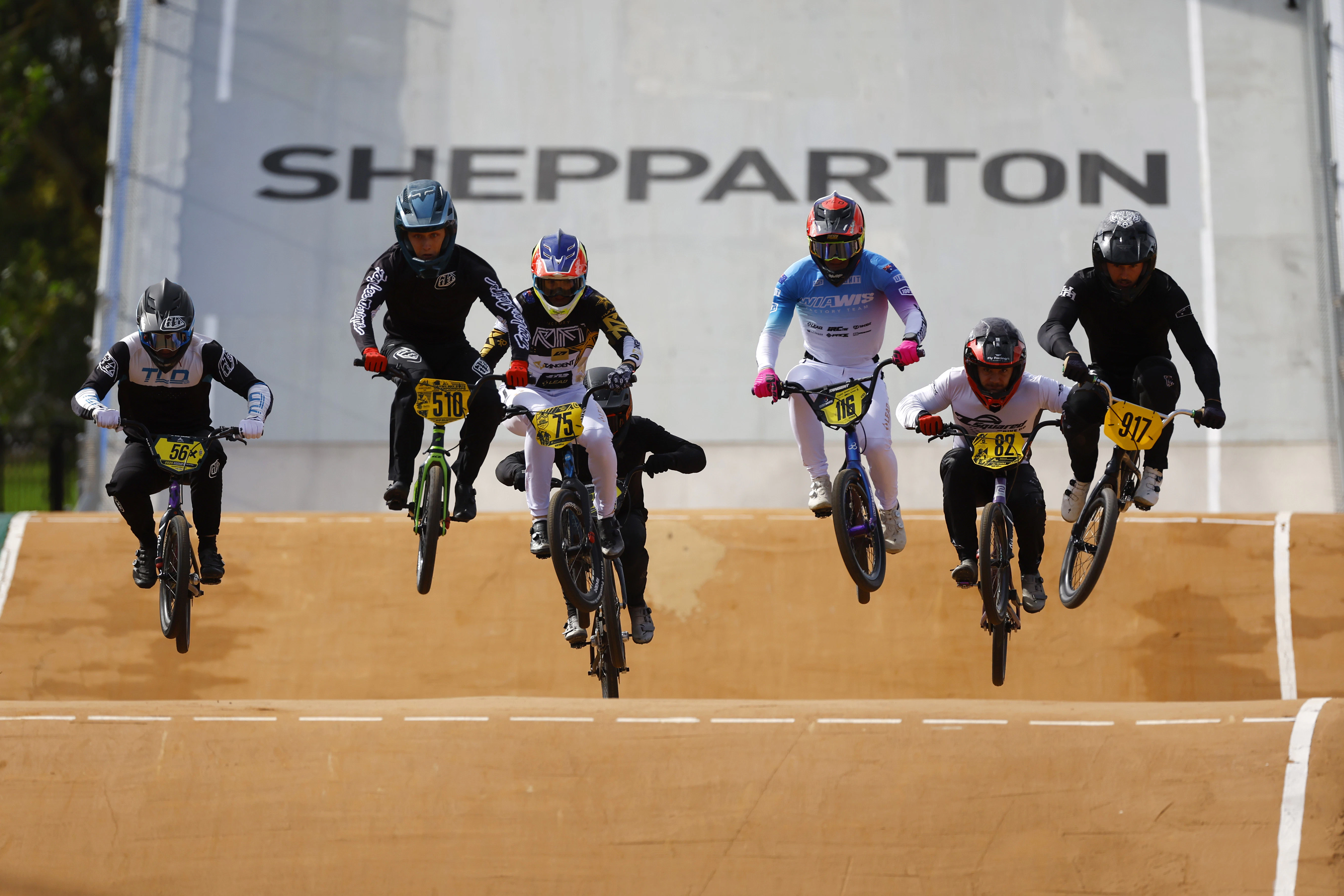BMX riders airborne during national championship racing in Shepparton