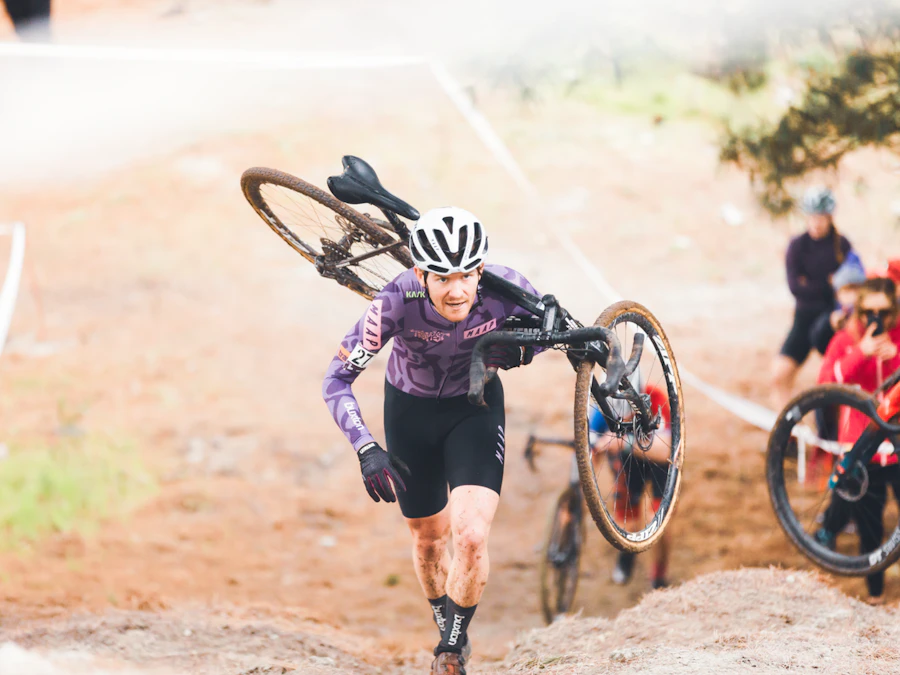 Competitor carrying their bike up a challenging course feature during cyclo-cross racing at the AusCycling National Cyclo-Cross Championships.