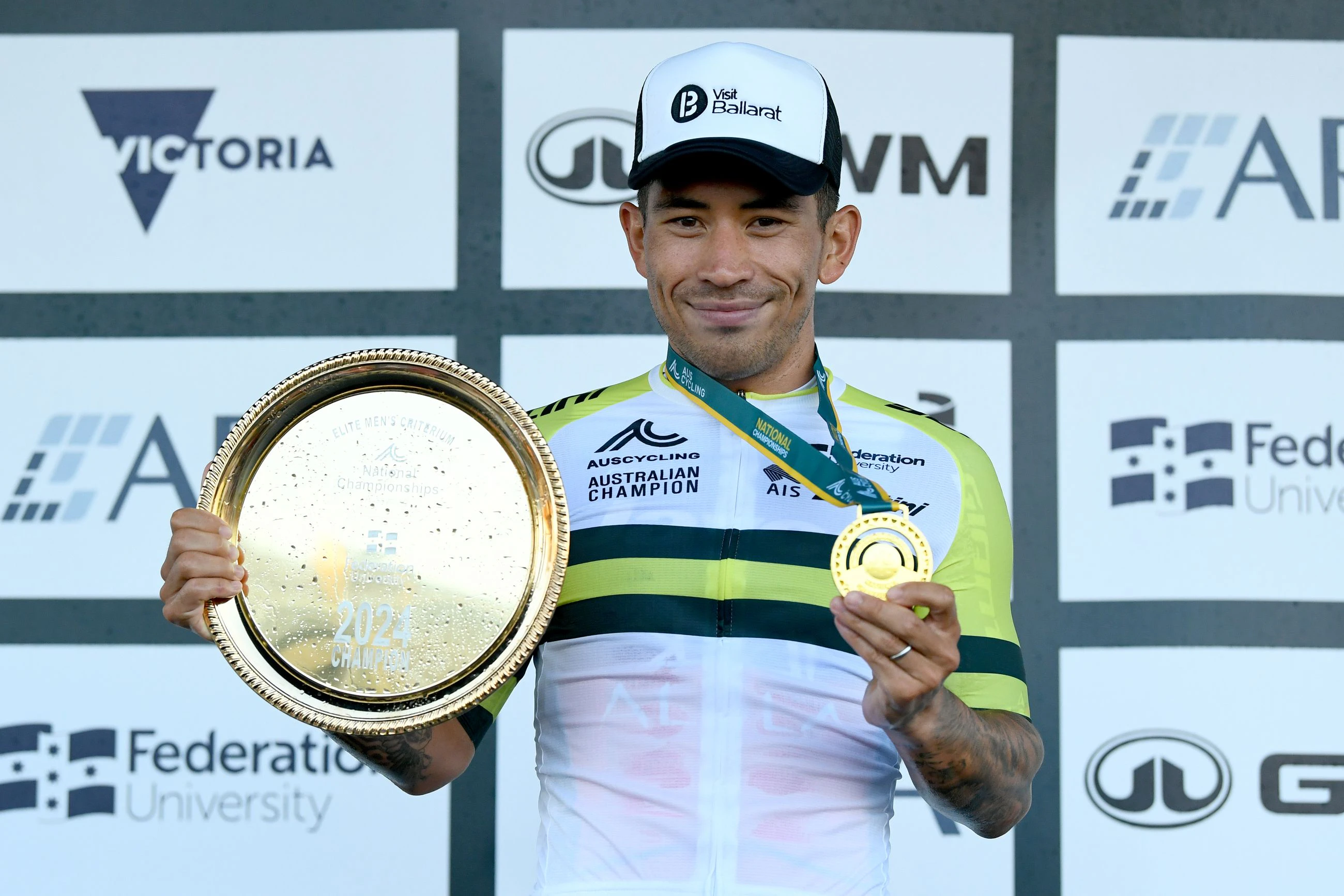 Caleb Ewan posing in the green-and-gold jersey as winner of the elite men's 2024 AusCycling Criterium National Championships in Ballarat, Victoria
