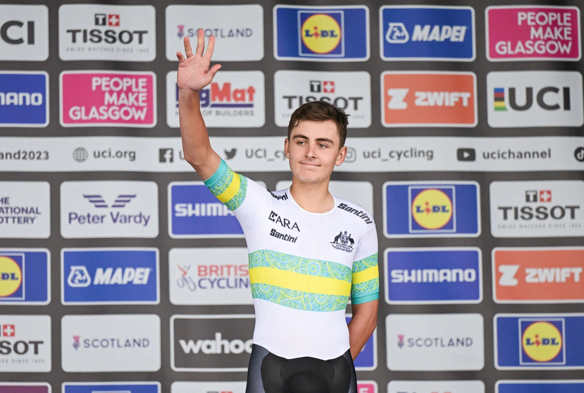 Hamish McKenzie, cyclist for ARA Australian Cycling Team, waves from the podium of a world championships