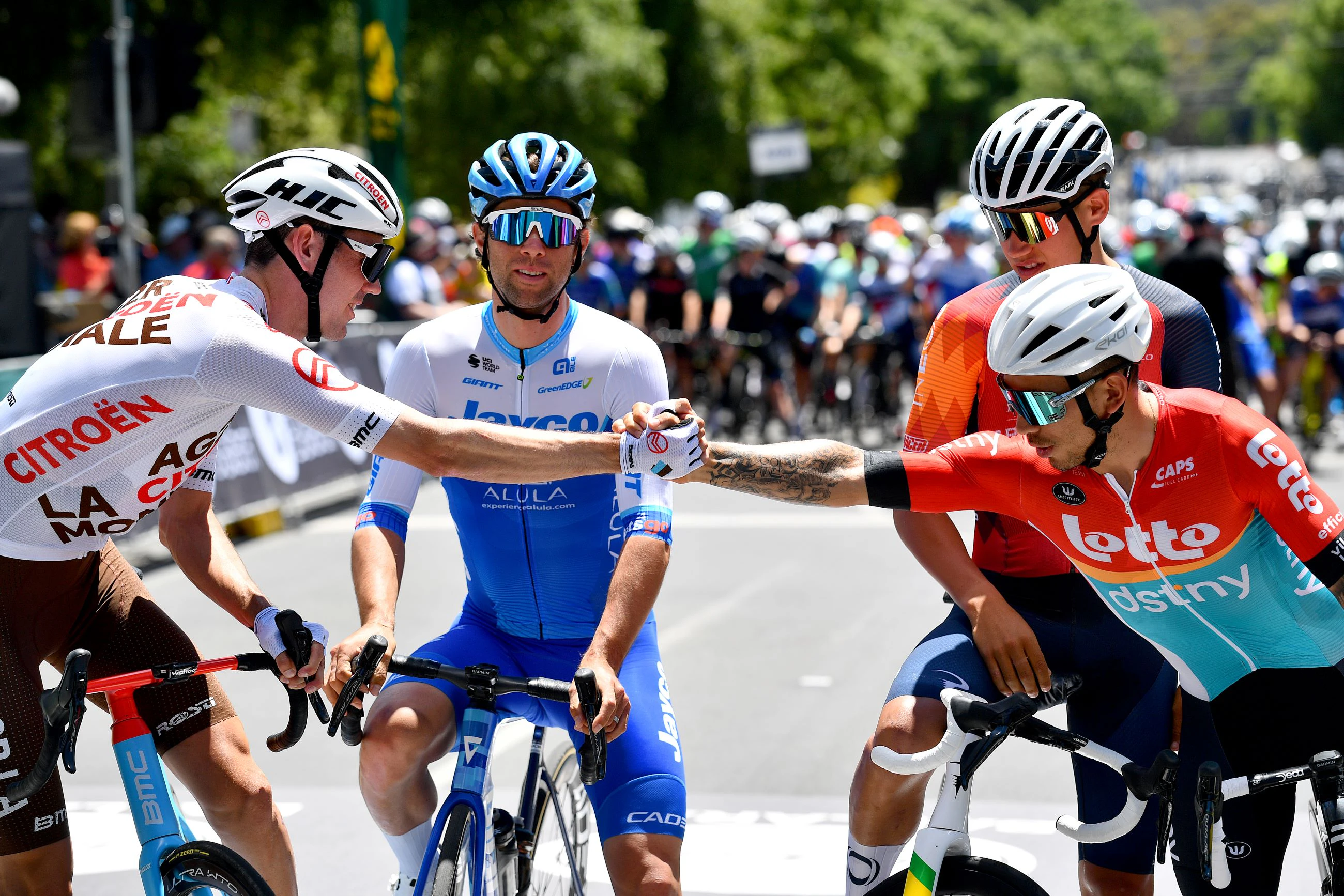 Ben O'Connor shakes hands with Caleb Ewan with Michael Matthews and Lucas Plapp looking on at the start list of the 2023 Road National Championships in Ballarat