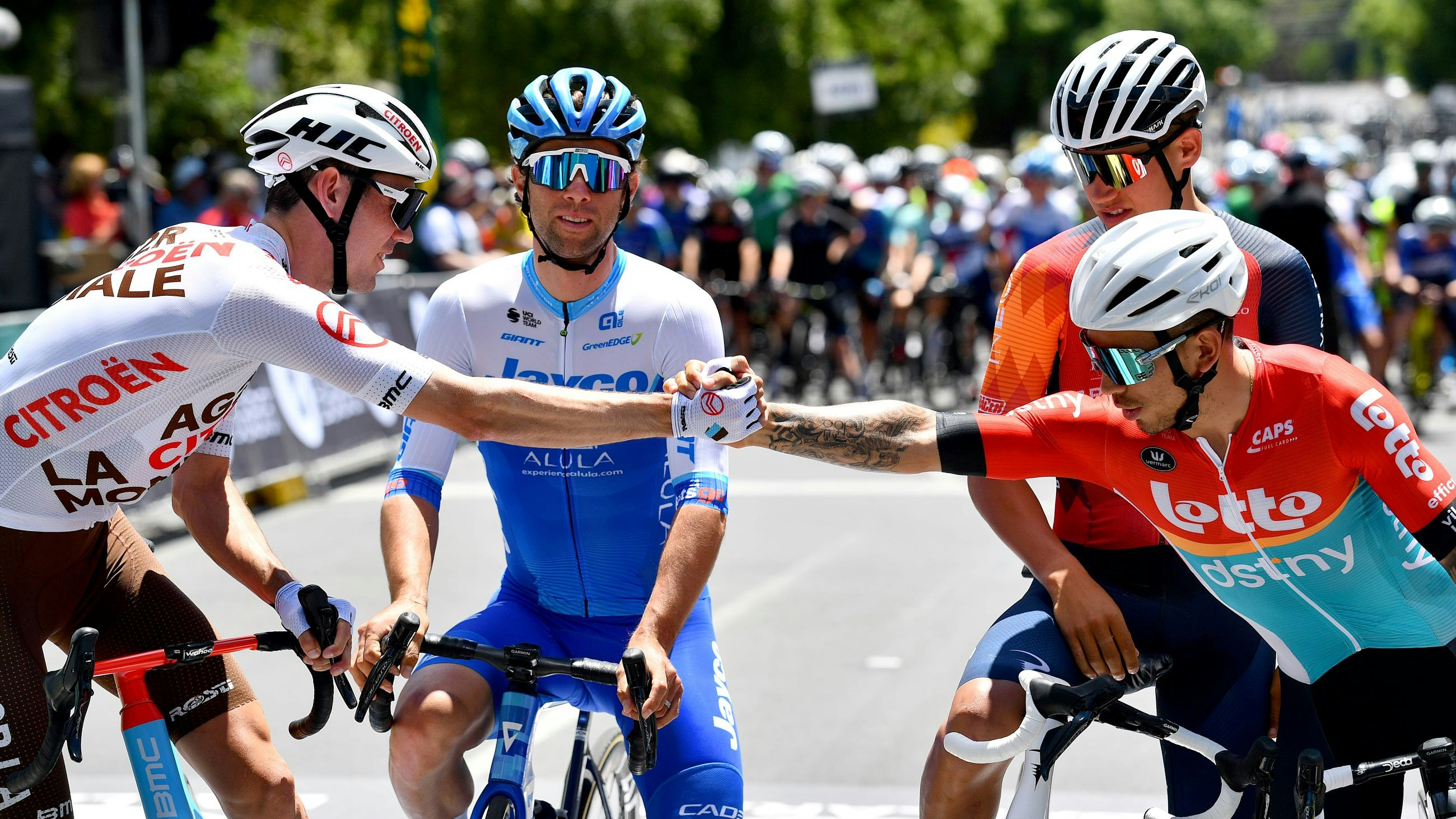 Ben O'Connor shakes hands with Caleb Ewan with Michael Matthews and Lucas Plapp looking on at the start list of the 2023 Road National Championships in Ballarat