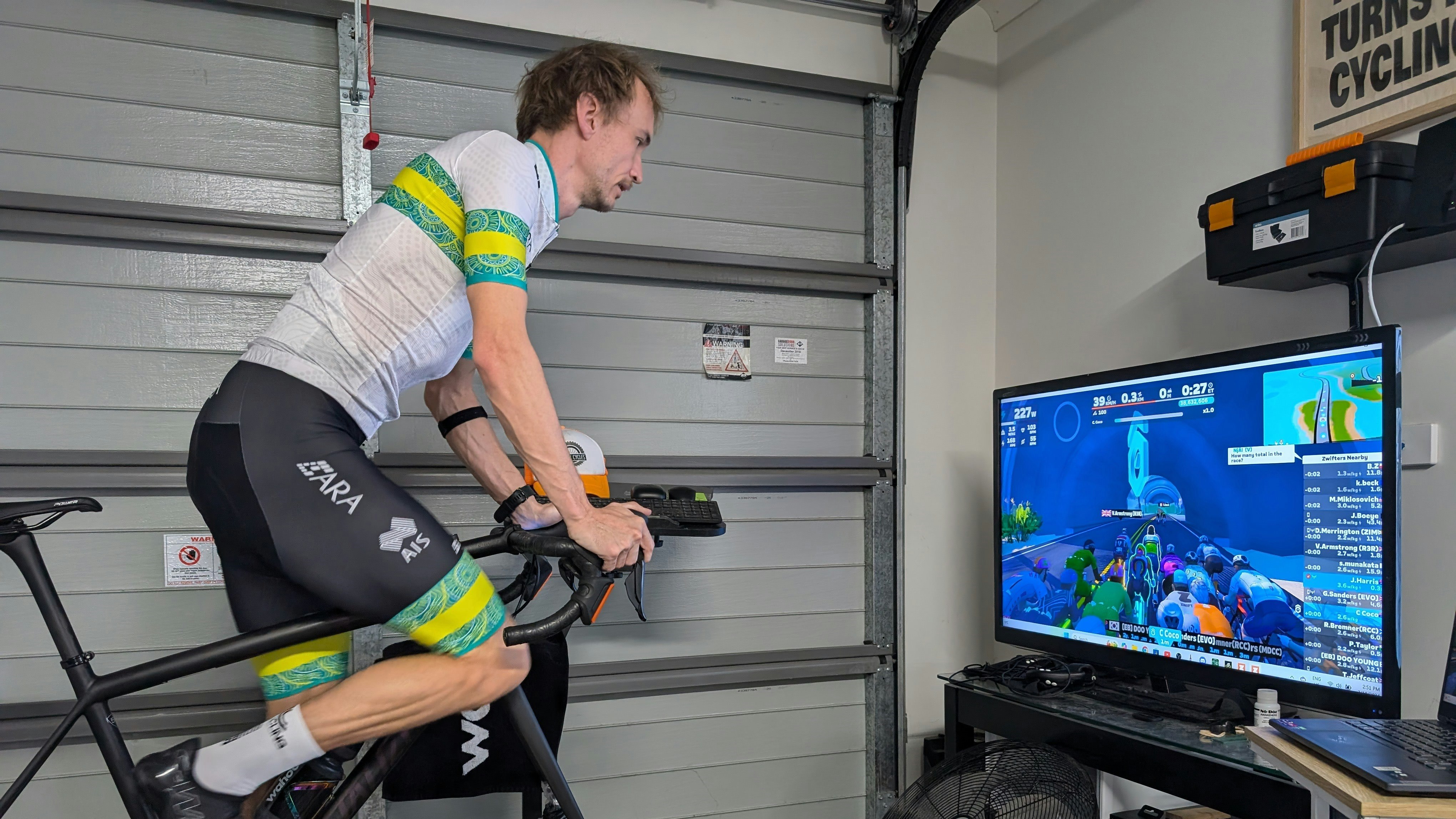 Tasmanian esports cyclist Josh Harris riding for the ARA Australian Cycling Team on a stationary trainer in his garage ahead of the 2024 UCI Cycling Esports World Championships.