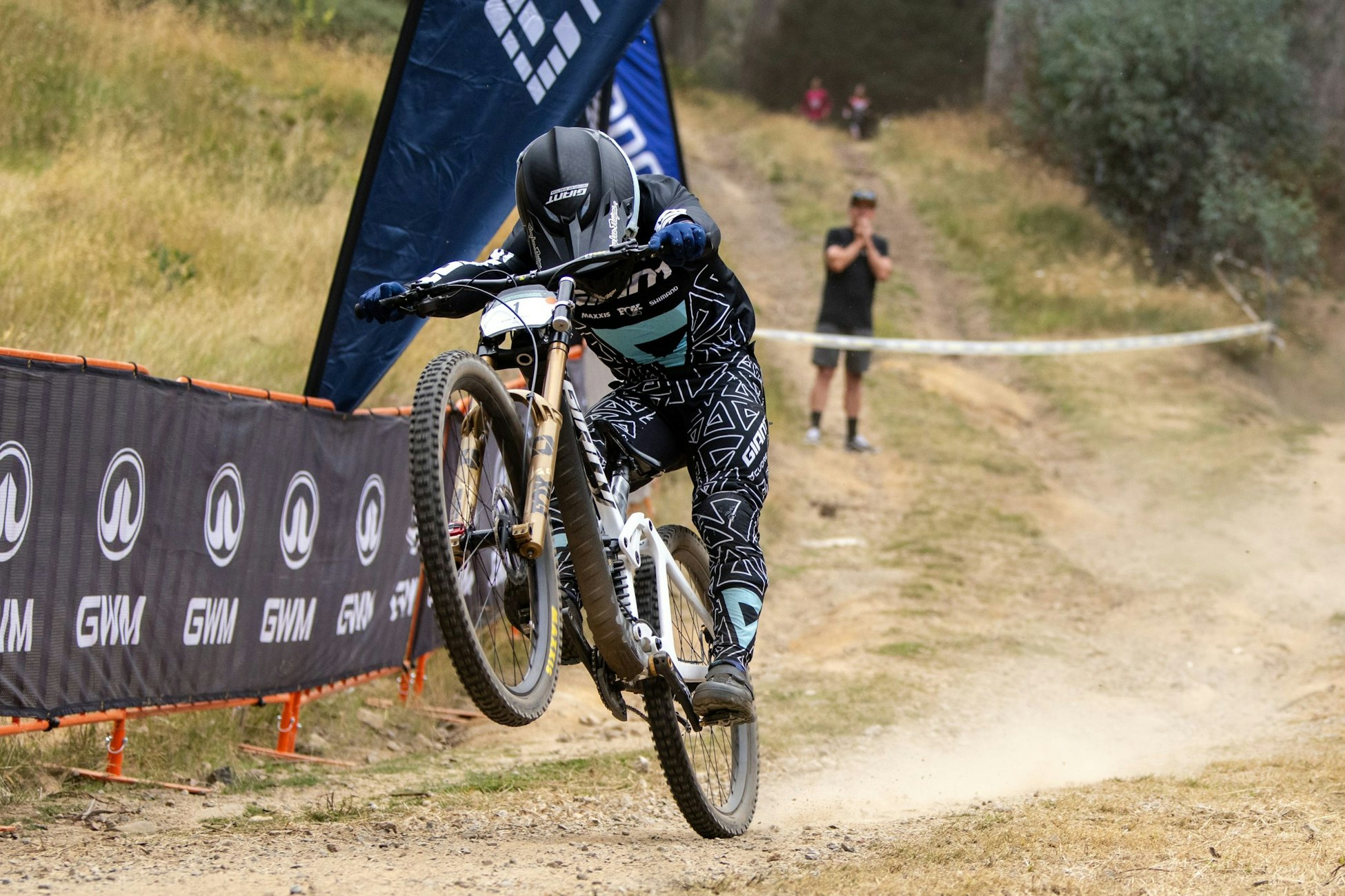 Australian downhill mountain biker Luke Meier-Smith wheelies across the finish line as he wins the final of the elite men's downhill at the 2025 GWM Mountain Bike National Championships at Mount Buller. Photo by Matt Rousu