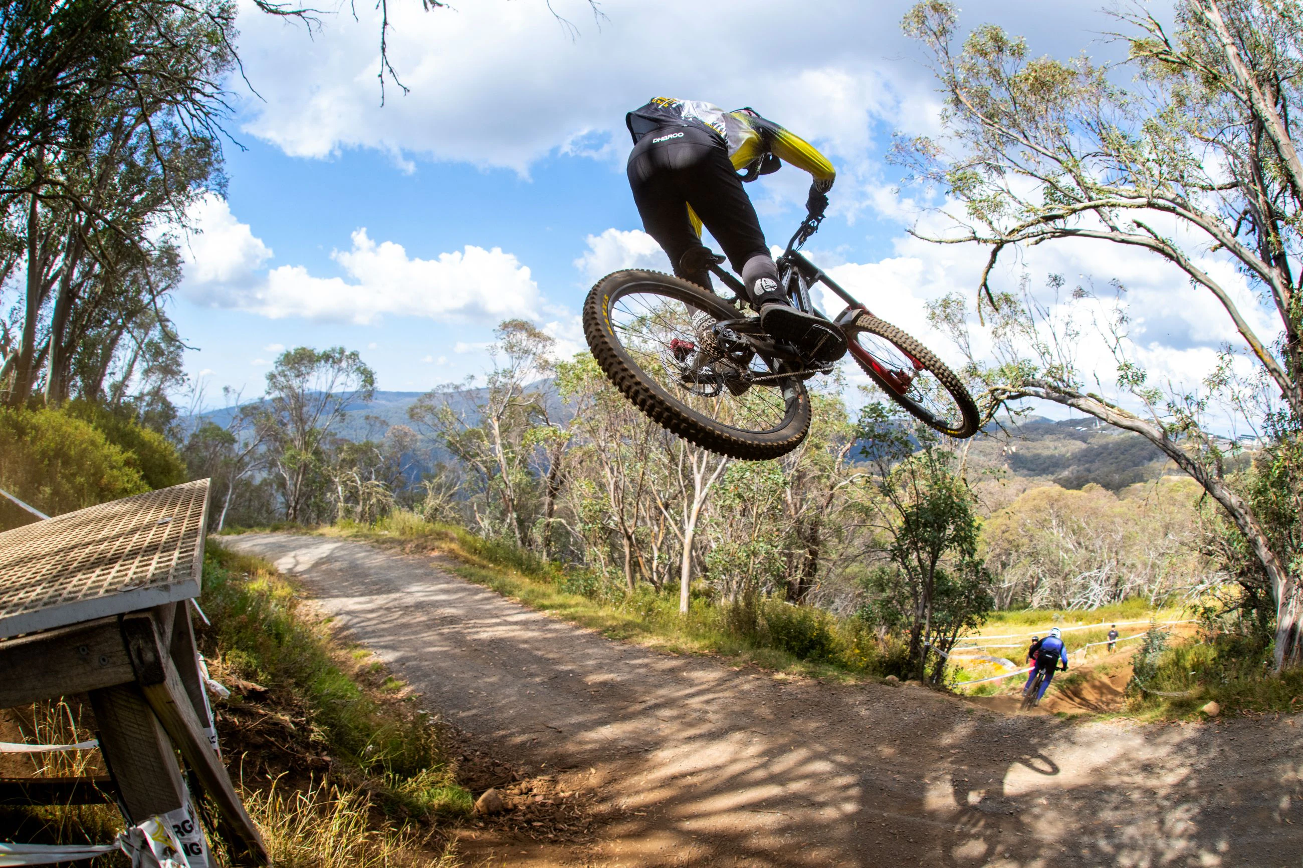 A mountain bike rider jumps over a road gap at the 2025 GWM Mountain Bike National Championships at Mount Buller. Photo by Matt Rousu