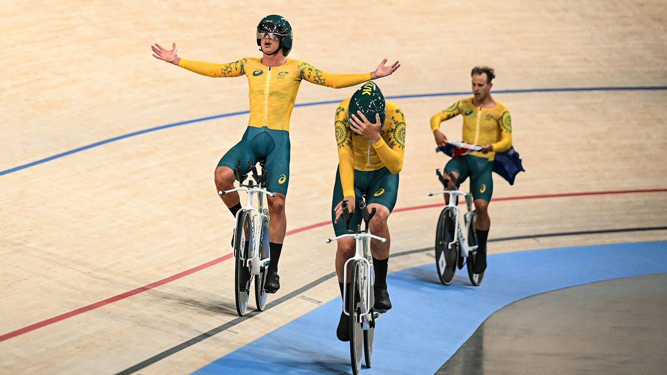 Oliver Bleddyn celebrates with Conor Leahy and Sam Welsford immediately after winning the men's team pursuit at the Paris 2024 Olympic Games in Paris