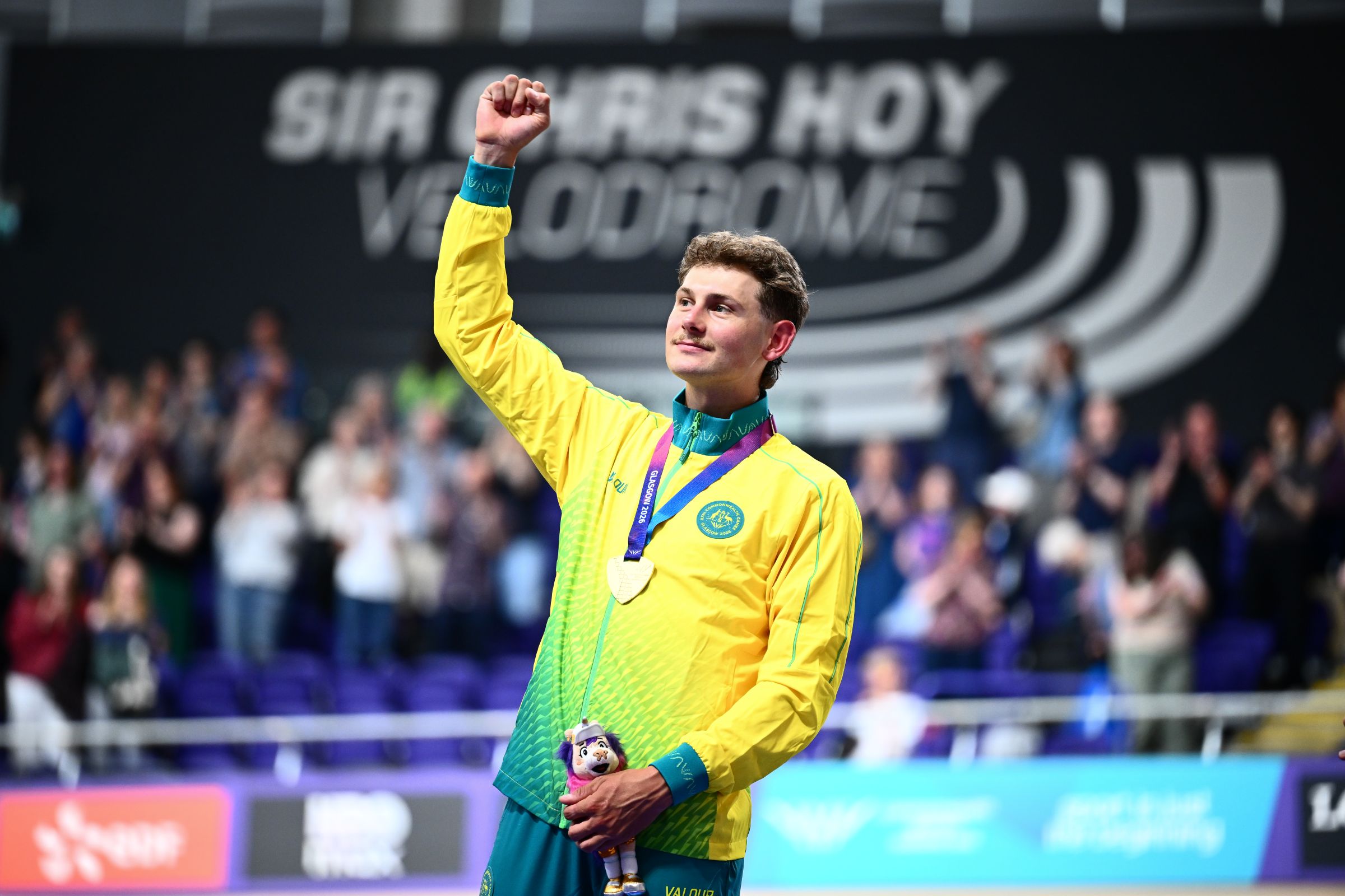 Australian cyclist Blake Agnoletto on the podium as he celebrates winning the elimination race at the 2026 Glasgow Commonwealth Games