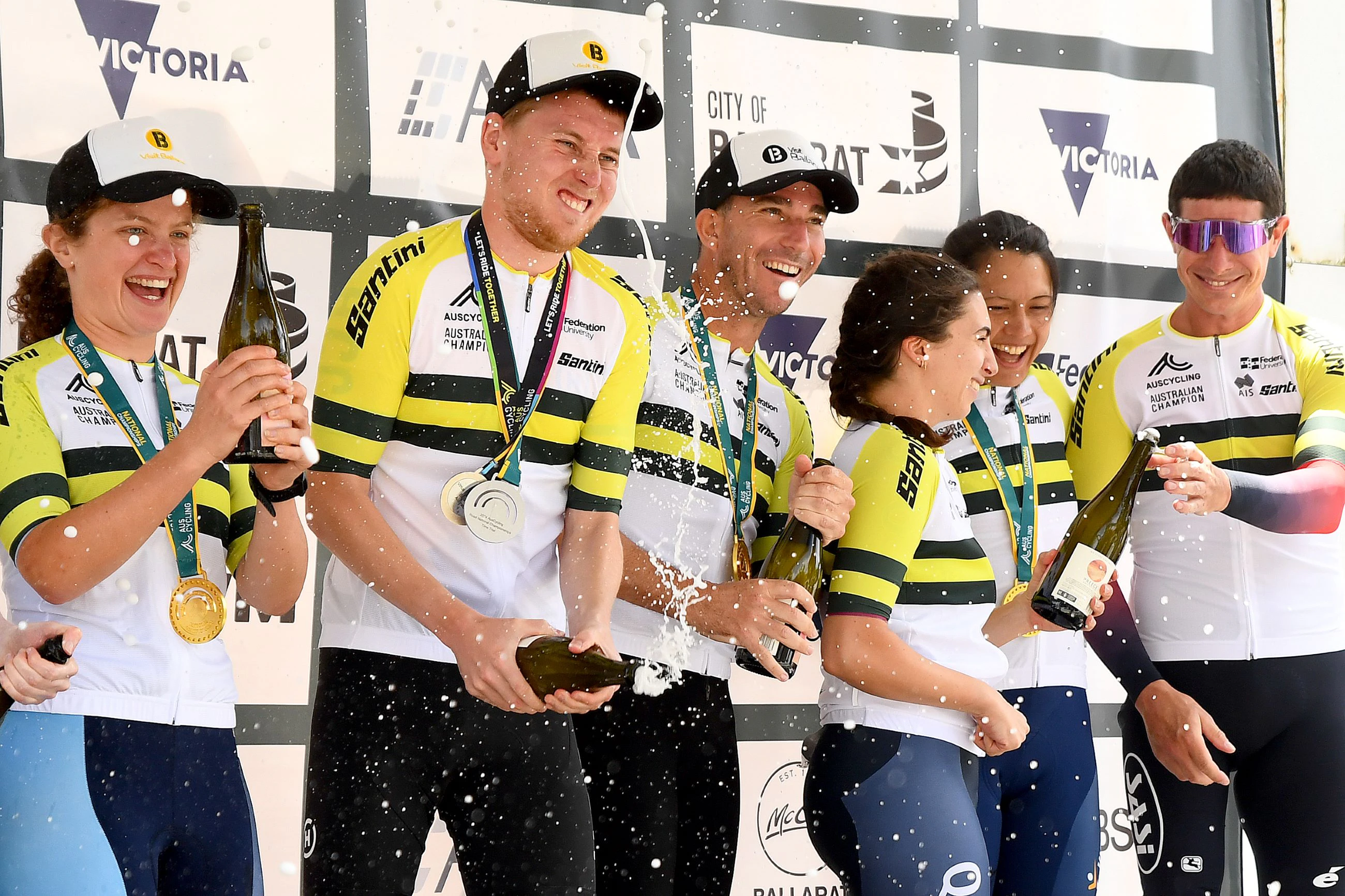 Australian road para-cycling national champions celebrating with a champagne spray on the podium in Ballarat in January 2024