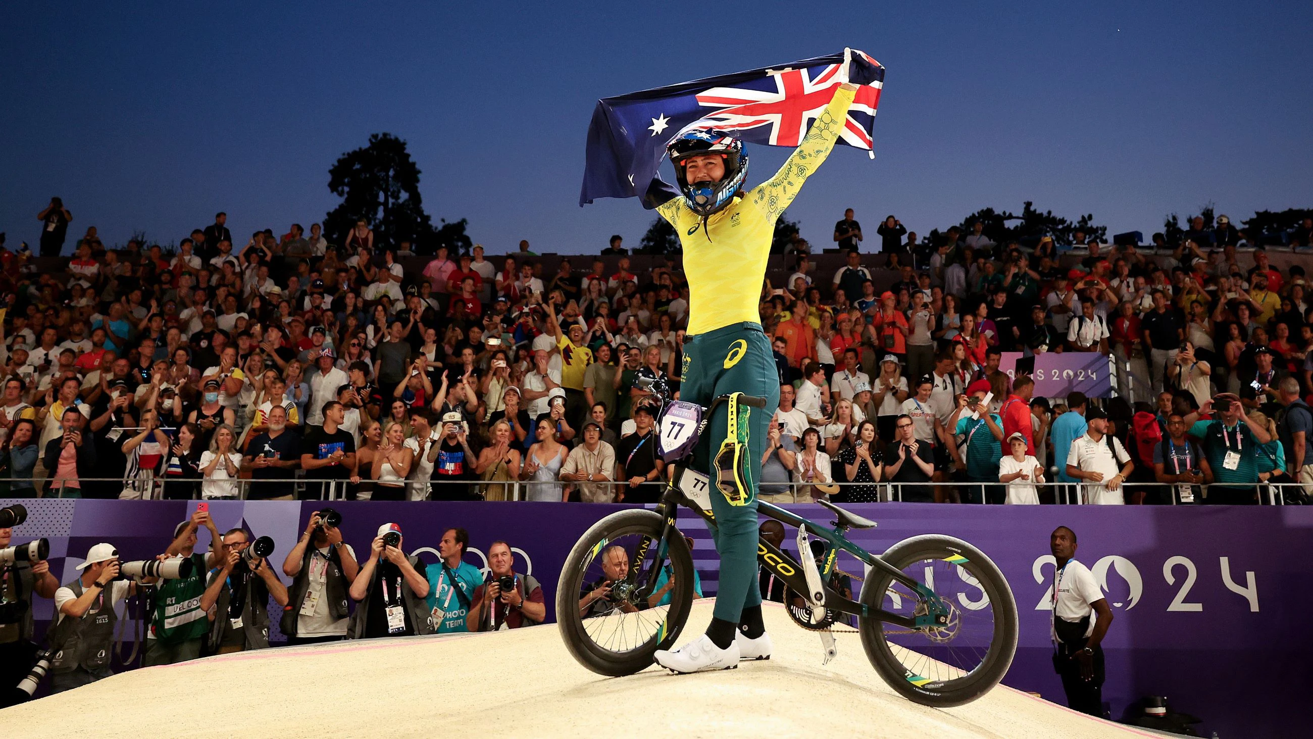 Australian BMX racer Saya Sakakibara celebrates with the Australian flag aloft after winning the women's BMX racing gold medal at the Paris 2024 Olympic Games