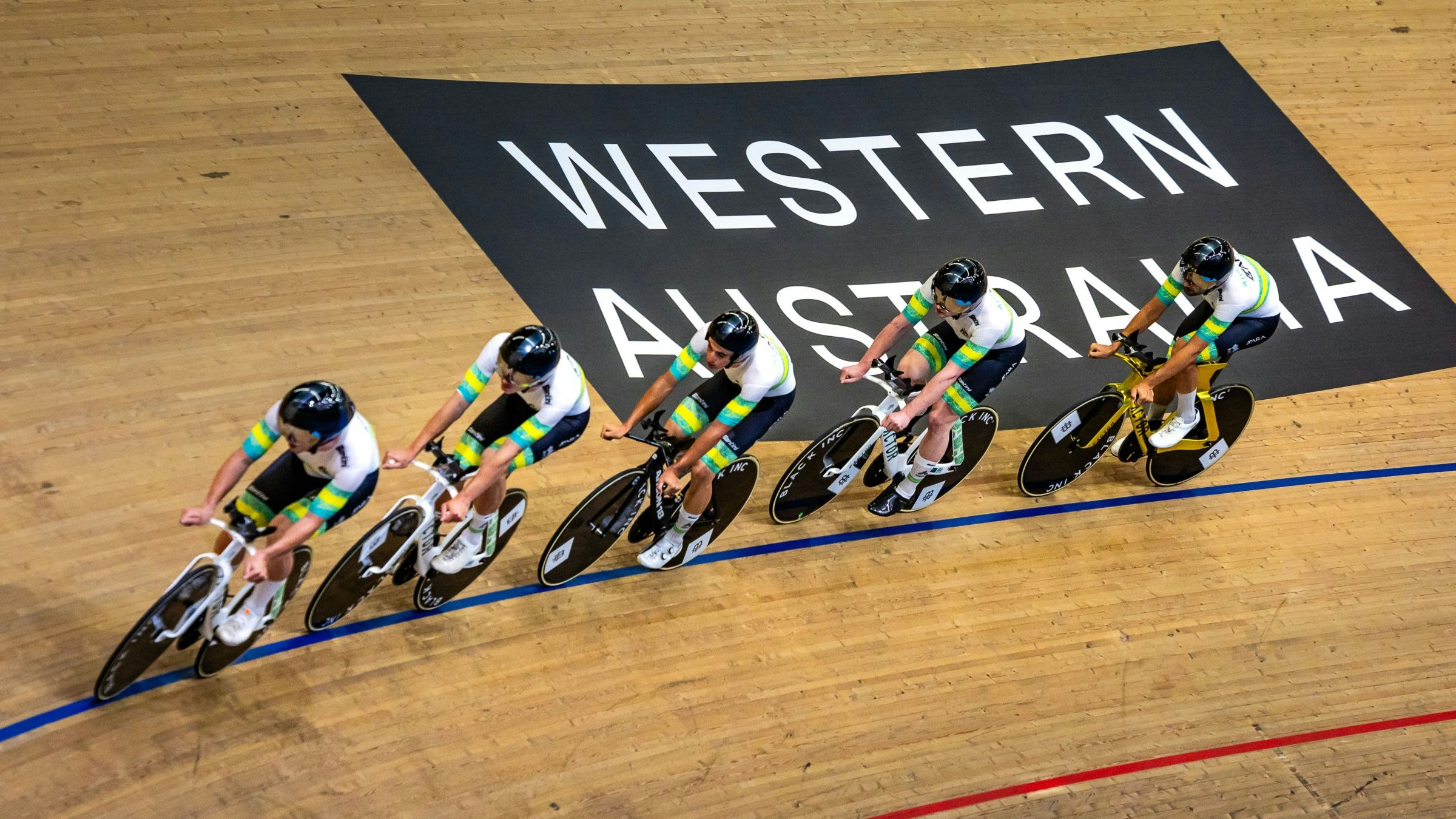 ARA Australian Cycling Team pass under the 'Western Australia' sign during training at the 2026 UCI Track World Cup in Perth
