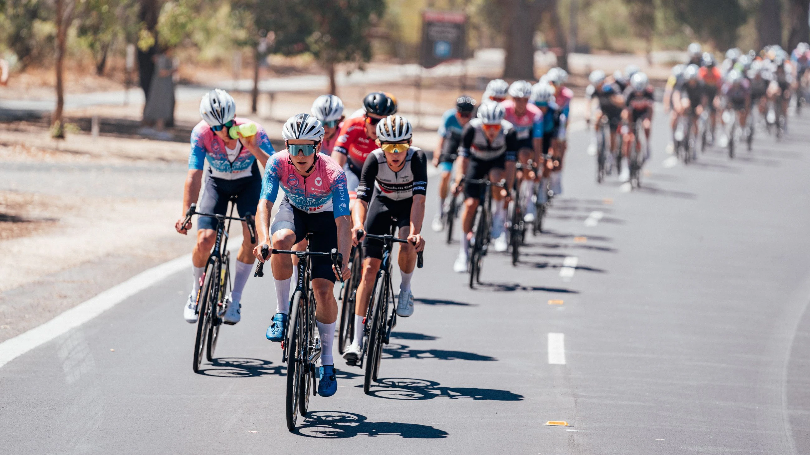 A peloton of junior under-19 road cyclists strung out during the AusCycling Road National Championships road race in Perth, Western Australia. Photo by Zac Williams
