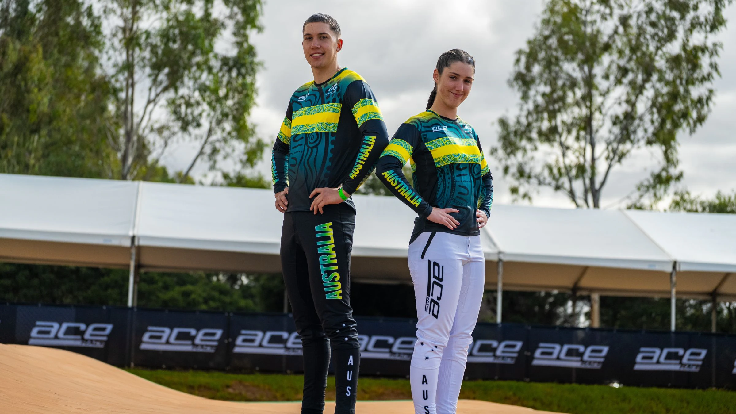 A male and female BMX Racing athlete model the 2026 Ace Race Team Australia jersey for the 2026 UCI BMX Racing World Championships in Brisbane