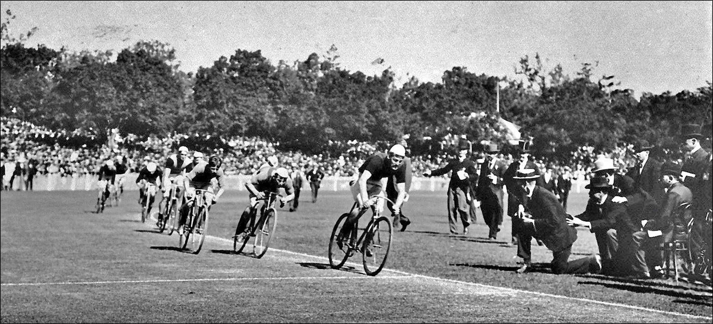 A truly historic photo showing the finish of the 1899 Austral Wheelrace on the grass track at the Melbourne Cricket Club Ground before a crowd of 27,000 spectators. Percy Beauchamp (150 yds) winning by lengths from William Matthews (170 y) and H. Thorn (200 y).