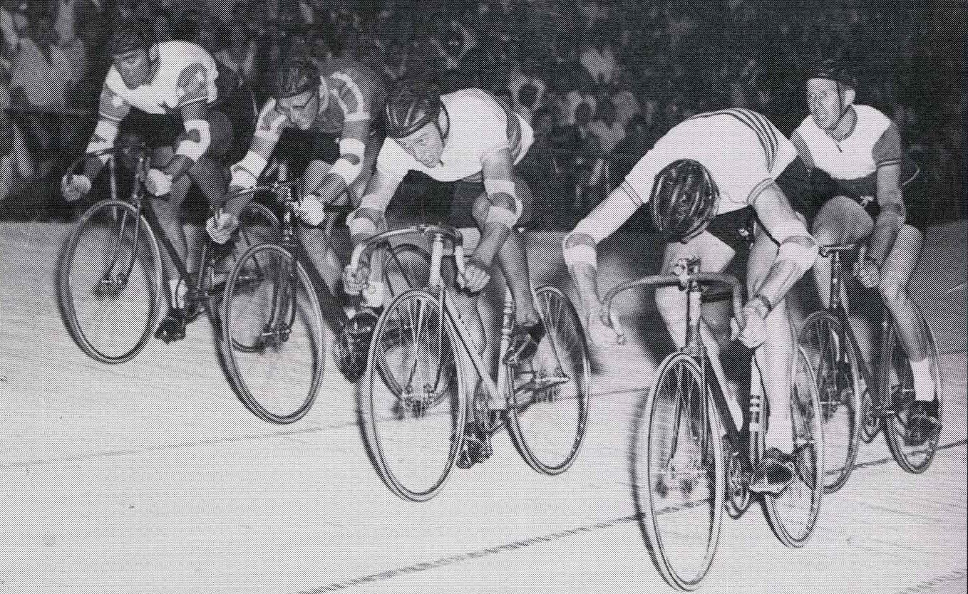 A sensational finish to the 1958 Austral Wheelrace at the Olympic Velodrome. On the bottom of the track, New Zealander Neil Geraghty rode a record time to win from 100 yards then it is Keith McKenzie in second, Russell Mockridge third, and Patterson on top of the track in fourth. Behind is Alan Geddes finishing fifth.