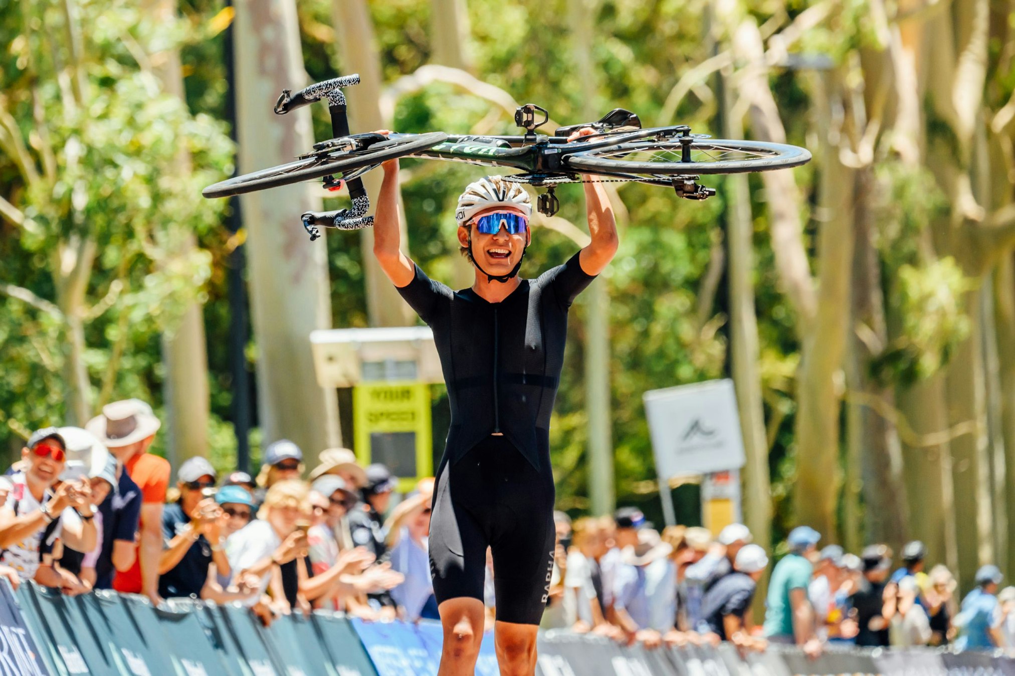 Ben Coates raises his bicycle aloft to celebrate winning the junior men's road race at the Westbridge Funds Road National Championships RoadNats26 in Perth