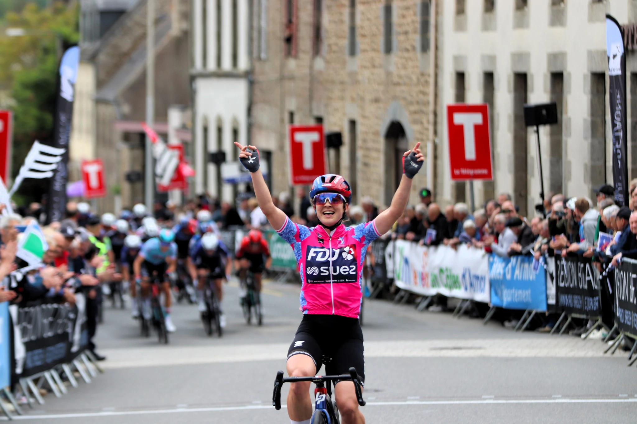 Australian cyclist Grace Brown celebrates with arms raised in the leaders jersey of the Bretagne Ladies Tour having crossed the line solo on Stage 3. Picture: Bretagne Ladies Tour.