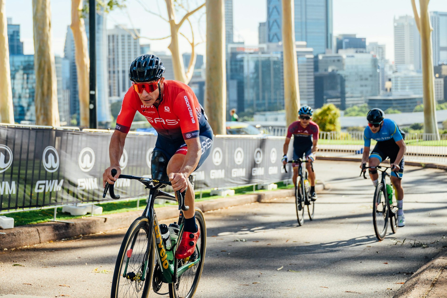 Darren Hicks leads a para-cycling  road race in front of the Perth skyline at the 2026 Westbridge Funds Road National Championships