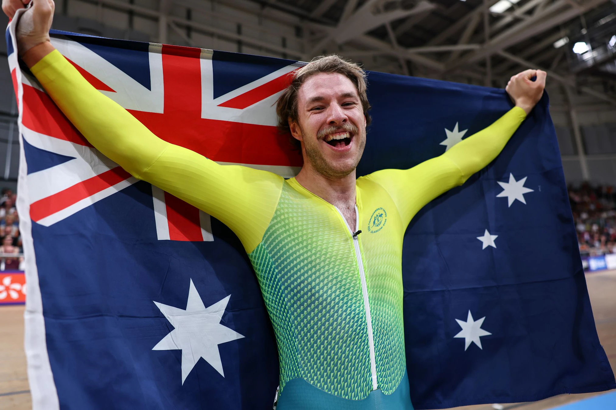 Leigh Hoffman of Australia celebrates gold with the Australian flag in the men's sprint at the Glasgow 2026 Commonwealth Games.
