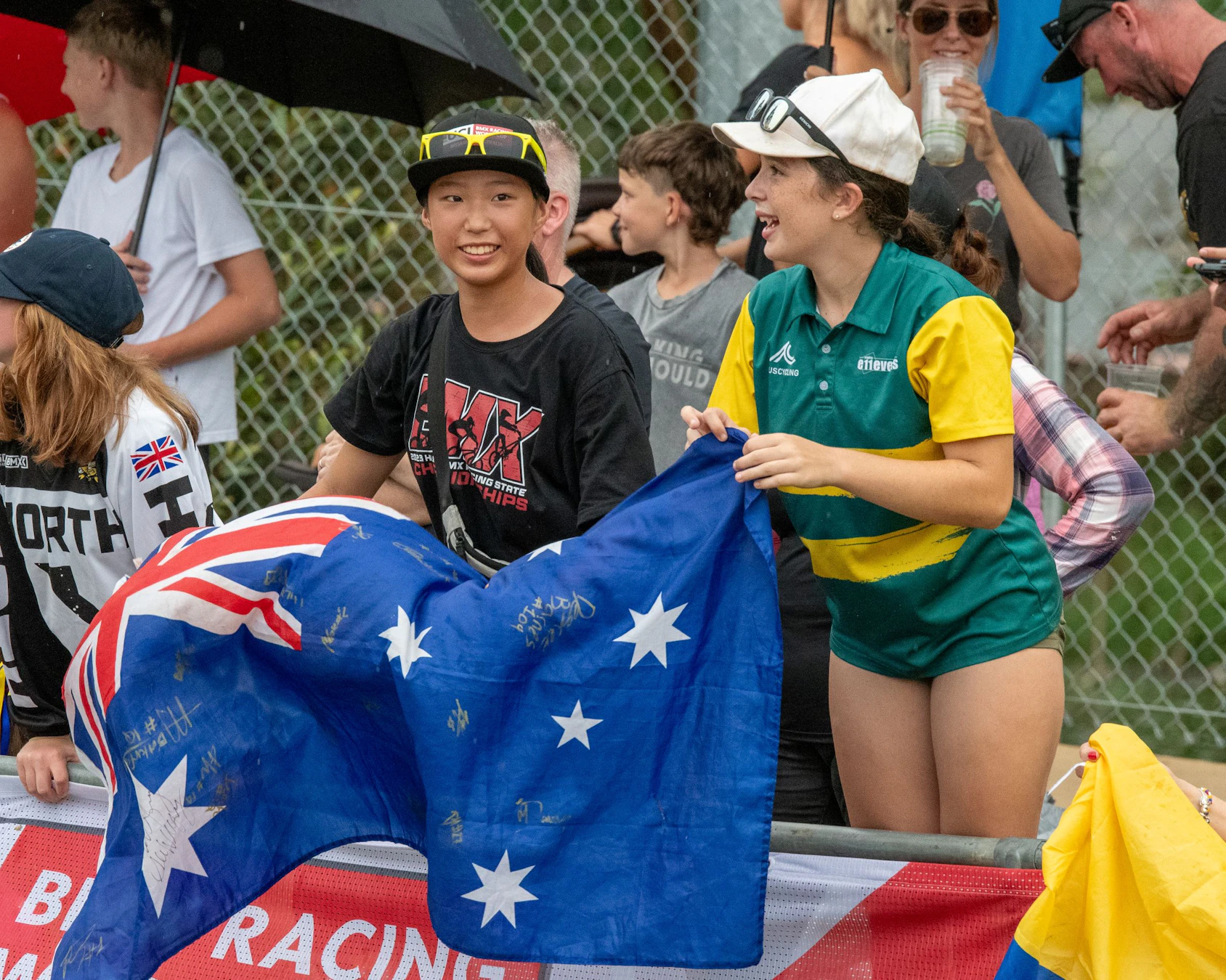 Two young Australian fans cheering while holding the flag of Australia in the crow of a UCI BMX Racing World Cup event in Brisbane, Queensland, Australia.