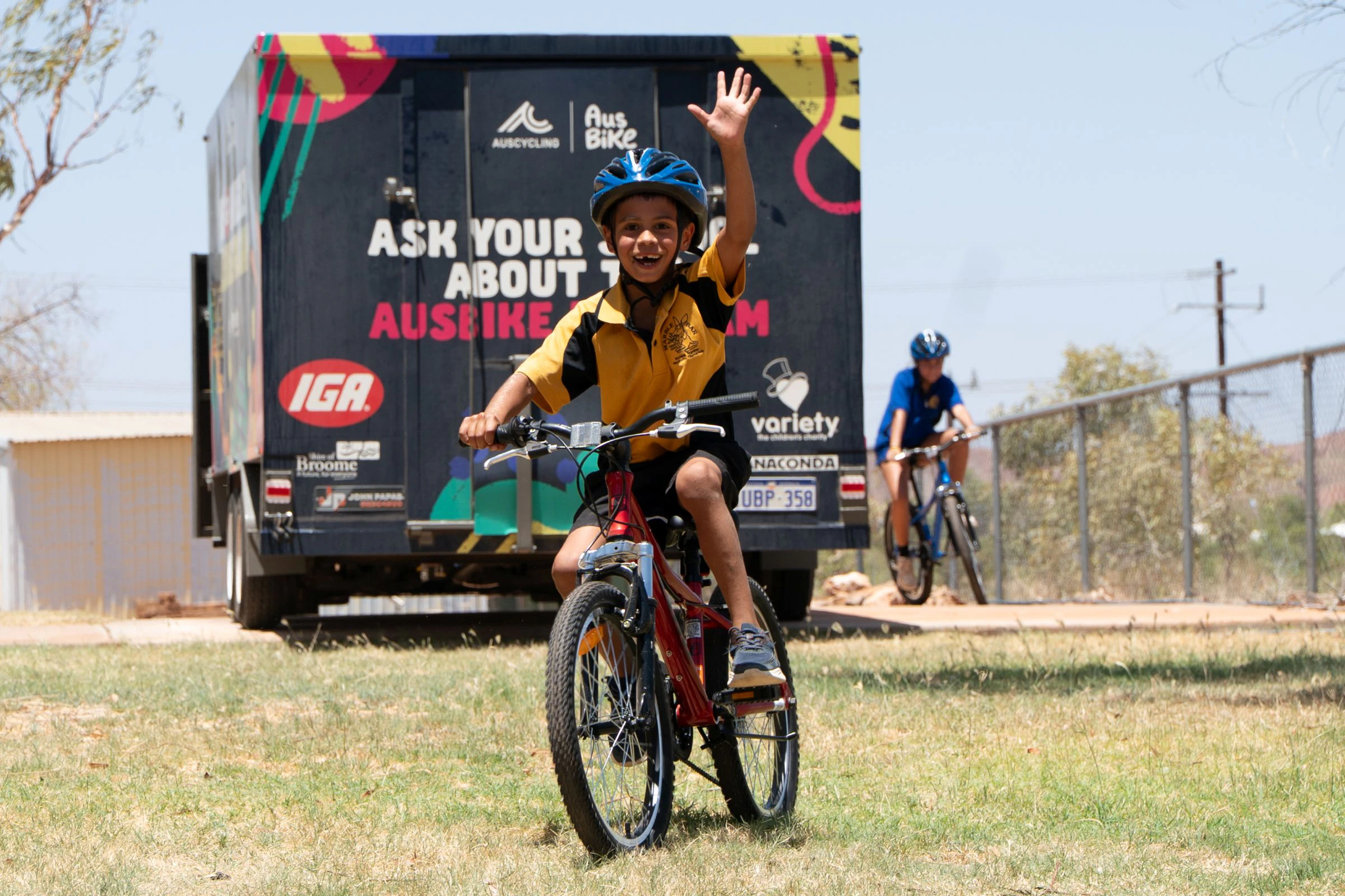 AusBike student waving while riding their bike