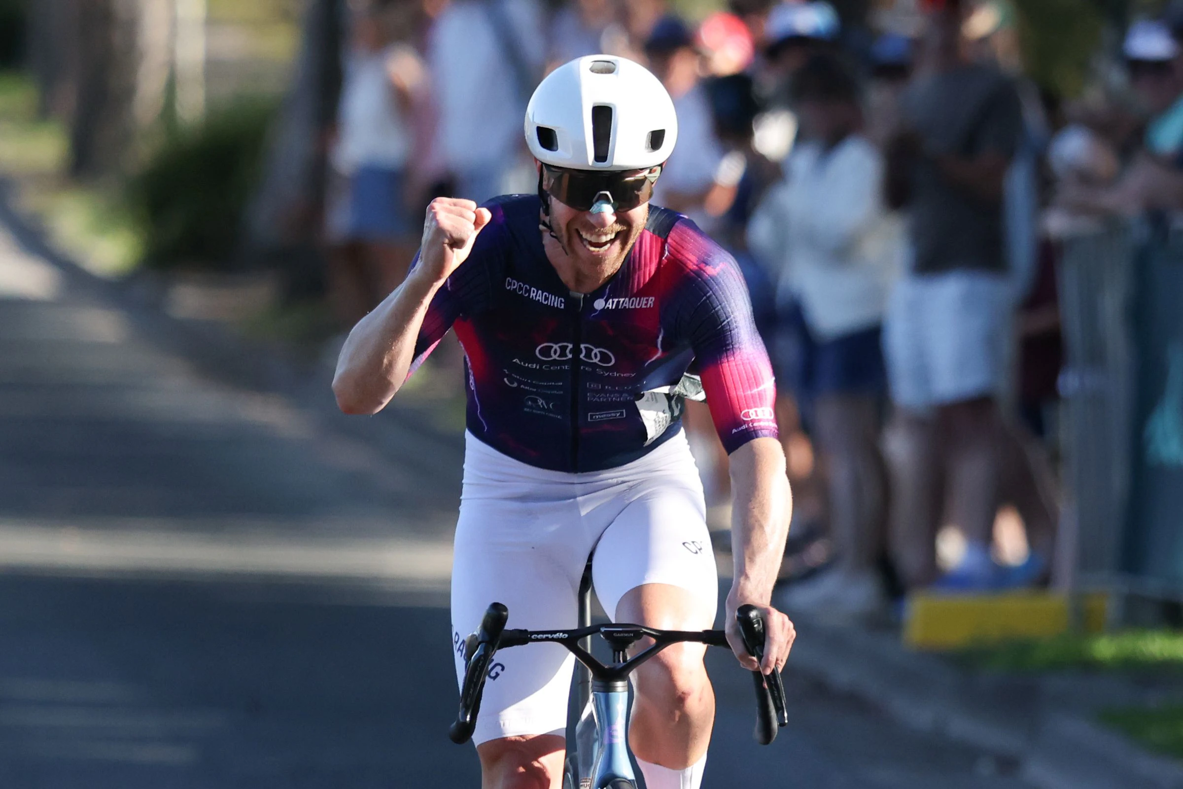 A male masters cyclist pumps the air after winning a masters road national championship road race