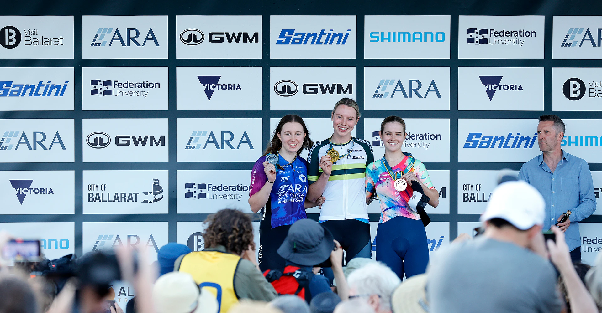 Winning Cyclists with media wall backdrop