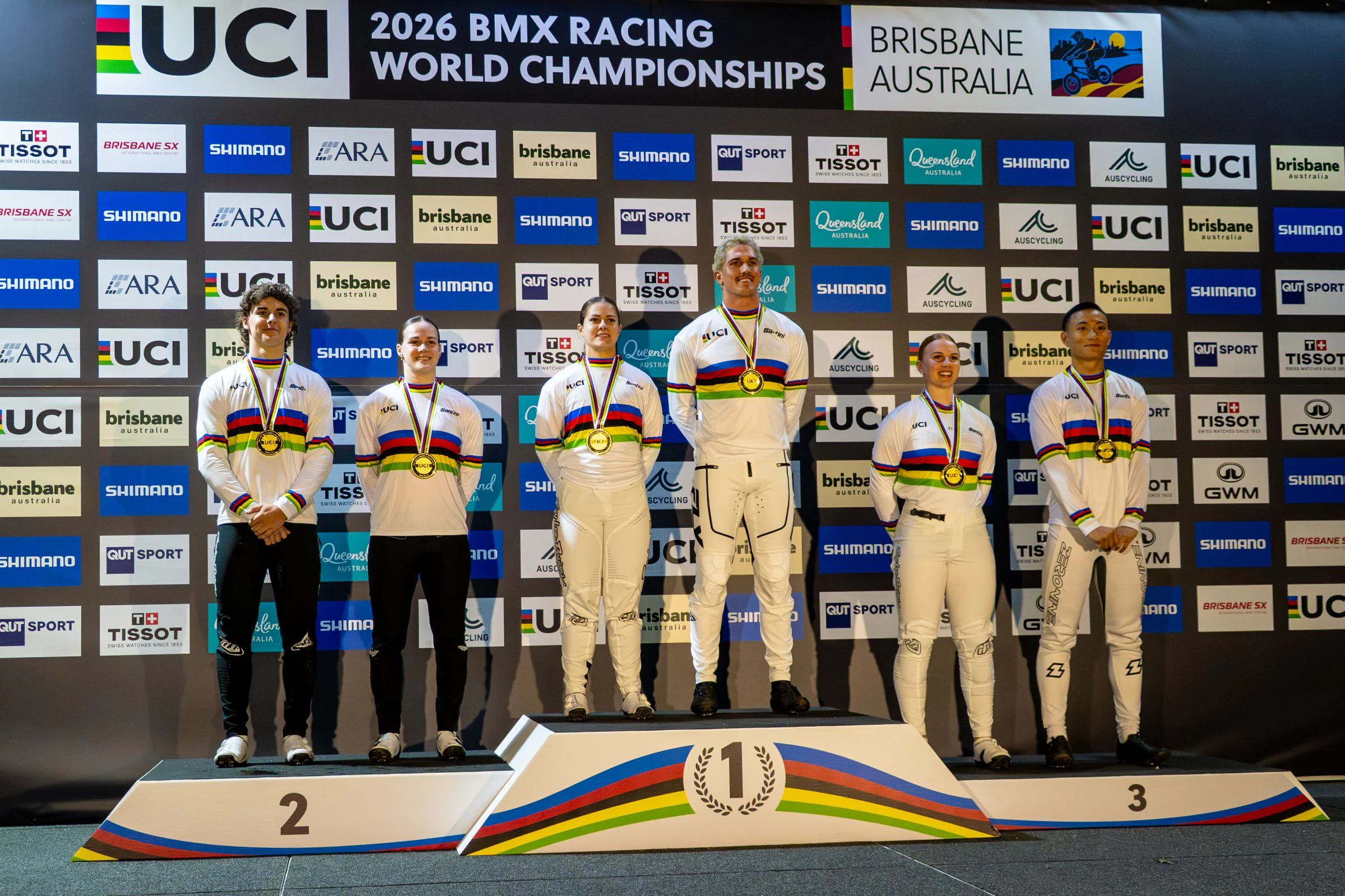 All six of the world champions from the 2026 UCI BMX Racing World Championship line up on the podium in rainbow jerseys