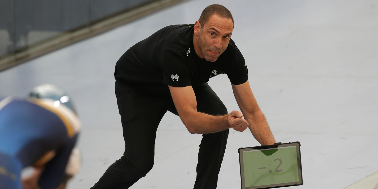 Track nationals coach showing lap time to cyclist